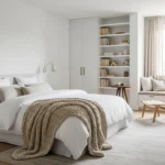 Serene white bedroom with layered textures and cozy lighting